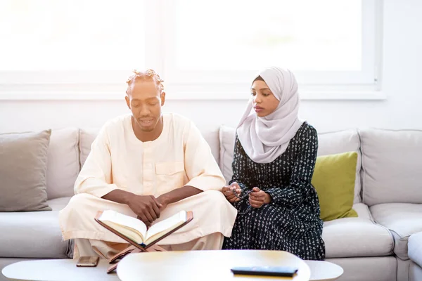 African couple at home reading quran — Stock Photo, Image