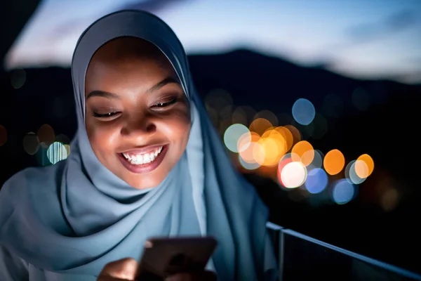 Fiatal muszlim nő éjszaka az utcán telefonál. — Stock Fotó
