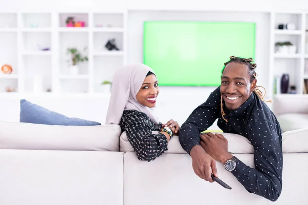 ソファに座っているアフリカのカップルテレビを一緒に見る — ストック写真