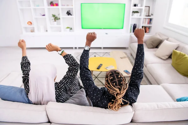 Pareja africana sentada en un sofá viendo televisión juntos — Foto de Stock