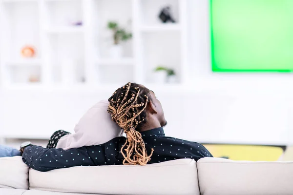 Pareja africana sentada en un sofá viendo televisión juntos — Foto de Stock