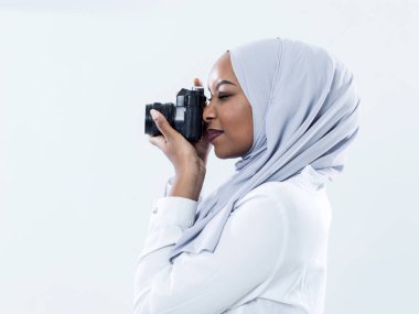 Afrikalı modern Müslüman kadın retro kamera kullanıyor.