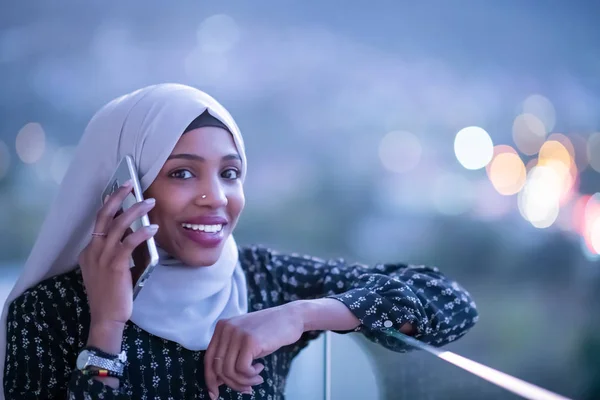 Ung Muselman kvinna på gata på natten användande telefon — Stockfoto