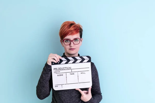 Donna in possesso di film applauso sullo sfondo ciano — Foto Stock