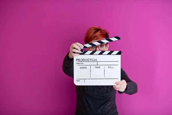 Mulher segurando filme palmas isolado no fundo rosa — Fotografia de Stock