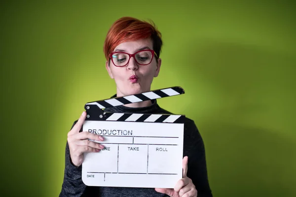 Mulher segurando filme palmas contra fundo verde — Fotografia de Stock