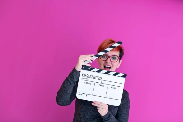 ピンクの背景に隔離された映画のクラッパーを持っている女性 — ストック写真