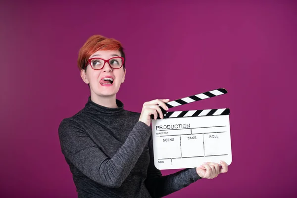 Mujer sosteniendo película clapper aislado en rosa fondo — Foto de Stock