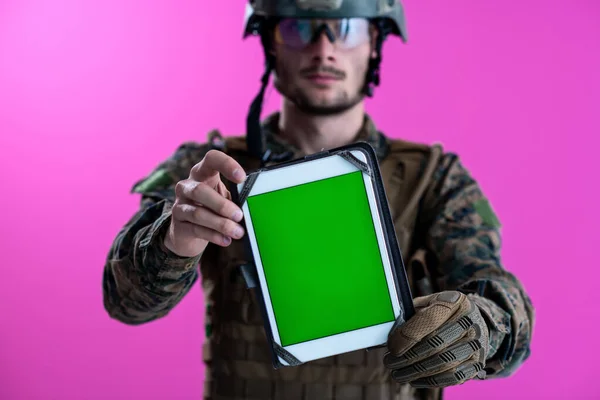 Voják ukazující tablet s prázdnou zelenou obrazovkou — Stock fotografie