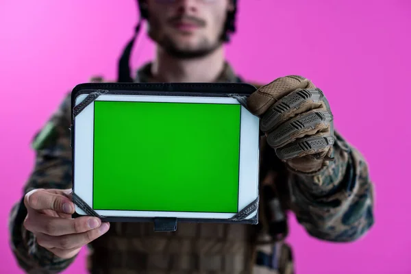 Soldado mostrando una tableta con una pantalla verde en blanco —  Fotos de Stock