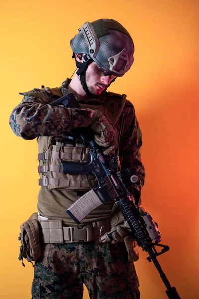 Modern soldier against yellow background — Stok fotoğraf