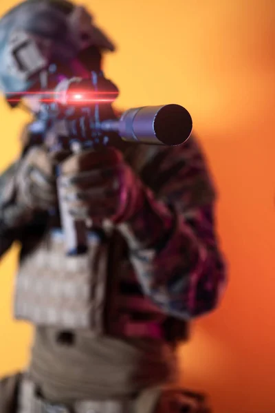 Soldato in azione puntando laser ottiche vista sfondo giallo — Foto Stock