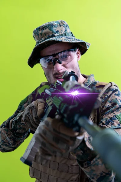 Soldat i aktion som syftar lasersiktsoptik grön bakgrund — Stockfoto