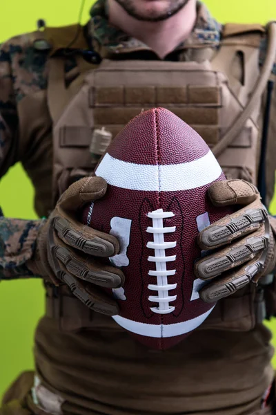 Pájka drží americký fotbalový míč — Stock fotografie