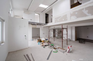 Büyük, modern, tamamlanmamış bir apartman dairesinde iskelesi olan inşaat sahasının içi.