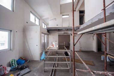 Büyük, modern, tamamlanmamış bir apartman dairesinde iskelesi olan inşaat sahasının içi.