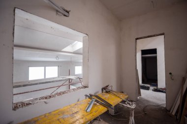 Büyük, modern, tamamlanmamış bir apartman dairesinde iskelesi olan inşaat sahasının içi.
