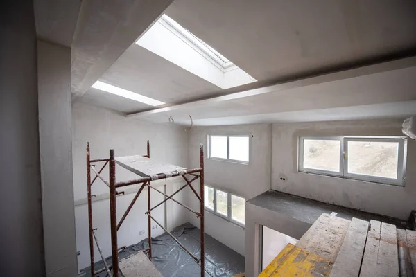 interior of construction site with scaffolding in a large modern unfinished duplex apartment