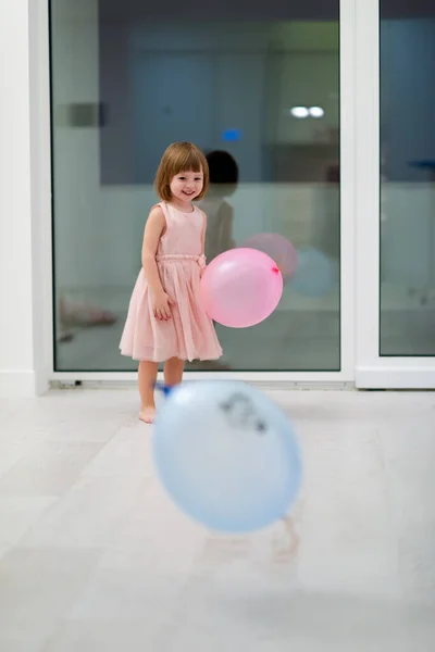 Szczęśliwy Cute Little Girl Różowej Sukience Korzystających Podczas Gry Balonami — Zdjęcie stockowe