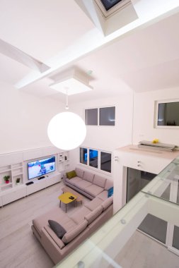 Lüks, modern, açık alan tasarımlı, iki katlı, beyaz duvarlı bir apartman dairesi.