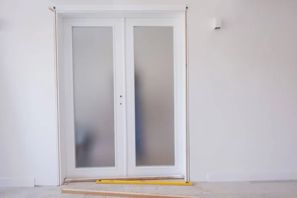 Męscy Pracownicy Stolarze Instalujący Wewnętrzne Szklane Drzwi Drewnianą Ramą Nowym — Zdjęcie stockowe