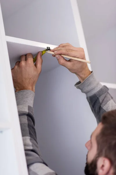 Jovem Trabalhador Profissional Escrevendo Medidas Durante Instalação Novo Mobiliário Cozinha — Fotografia de Stock