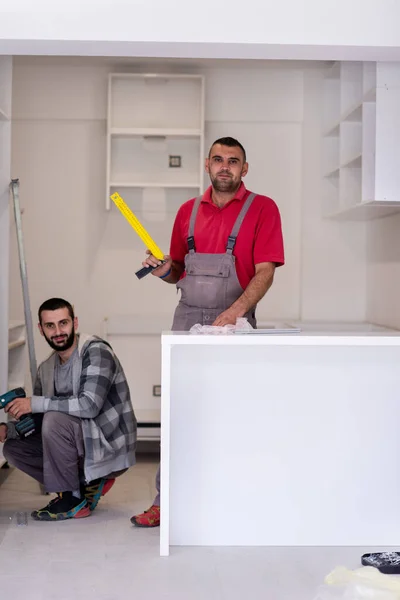 新风格现代厨房家具安装过程中两名专业工作人员的肖像 — 图库照片