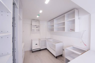 Ahşap dolapları olan lüks bir evde, güzel, parlak, temiz, bitmemiş bir mutfak üzerinde çalışmalar devam ediyor.