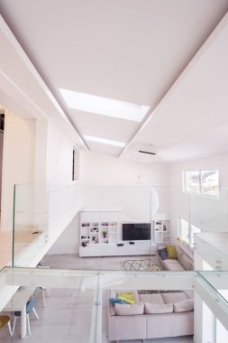 Lüks, modern, açık alan tasarımlı, iki katlı, beyaz duvarlı bir apartman dairesi.