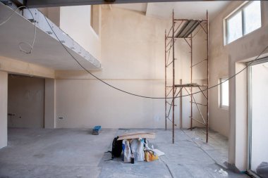 Büyük, modern, tamamlanmamış bir apartman dairesinde iskelesi olan inşaat sahasının içi.