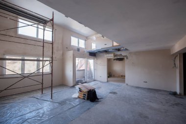 Büyük, modern, tamamlanmamış bir apartman dairesinde iskelesi olan inşaat sahasının içi.