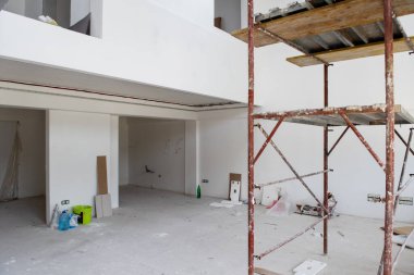 Büyük, modern, tamamlanmamış bir apartman dairesinde iskelesi olan inşaat sahasının içi.