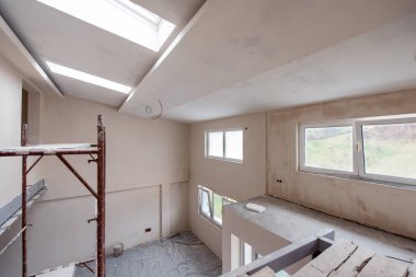 Büyük, modern, tamamlanmamış bir apartman dairesinde iskelesi olan inşaat sahasının içi.