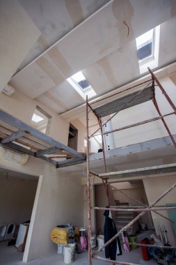 Büyük, modern, tamamlanmamış bir apartman dairesinde iskelesi olan inşaat sahasının içi.