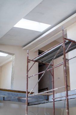 Büyük, modern, tamamlanmamış bir apartman dairesinde iskelesi olan inşaat sahasının içi.