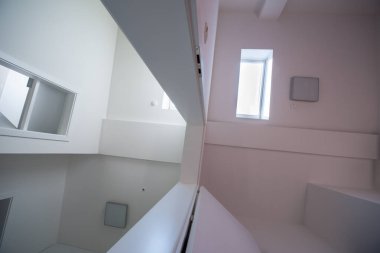 Halojen benekli lambalar ve çatı pencereleri olan bir ev ya da daireye bakıyordum. Gergin tavan beyaz ve karmaşık şekil