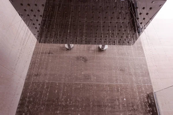 現代のバスルームの正方形のシャワーヘッドから流れる水近代的なバスルームに水滴と現代的なエレガントなステンレス製のシャワー — ストック写真