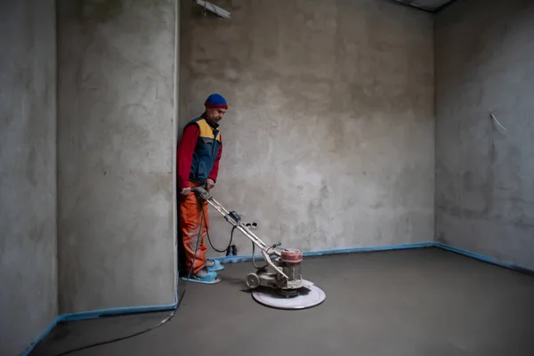 Lavoratore Esecuzione Lucidatura Sabbia Cemento Massetto Sul Cantiere Nuovo Appartamento — Foto Stock