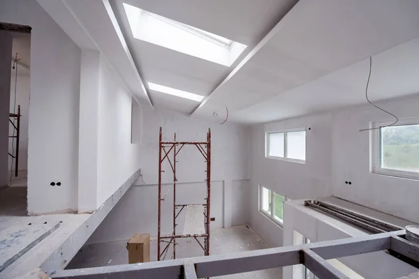 interior of construction site with scaffolding in a large modern unfinished duplex apartment