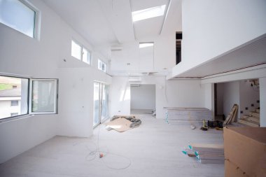 Tamamlanmamış, modern, iki katlı, beyaz duvarlı ve yakında taşınmaya hazır bir apartman dairesi.