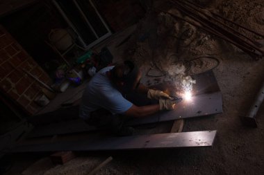 Koruyucu maskeli kaynakçı çelik yapılar ve inşaat sektöründe parlak kıvılcımlar.