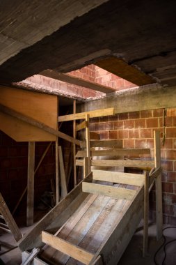 Pencereleri ve kırmızı tuğlalı inşaat alanı olan yeni iki katlı apartman dairesinin inşaatı devam ediyor.