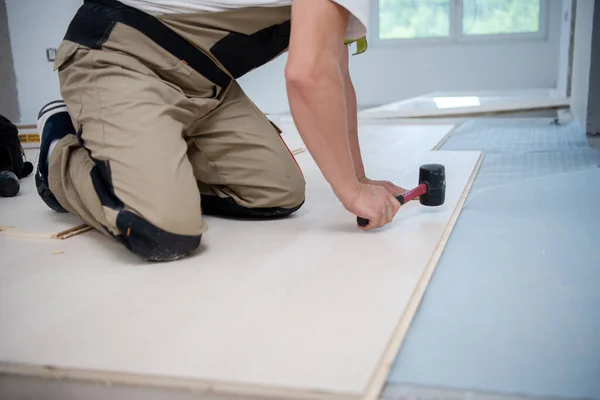 Profi Schreiner Mit Gummihammer Bei Der Verlegung Eines Neuen Laminatfußbodens — Stockfoto