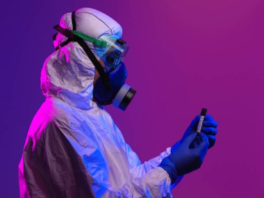 Coronavirus, doktorun elinde kovid 19 virüslü kan örneği tüpü var. Biyolojik tehlike salgını var Koruyucu maske, kostüm ve ışıltı.