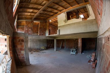 Pencereleri ve kırmızı tuğlalı inşaat alanı olan yeni iki katlı apartman dairesinin inşaatı devam ediyor.