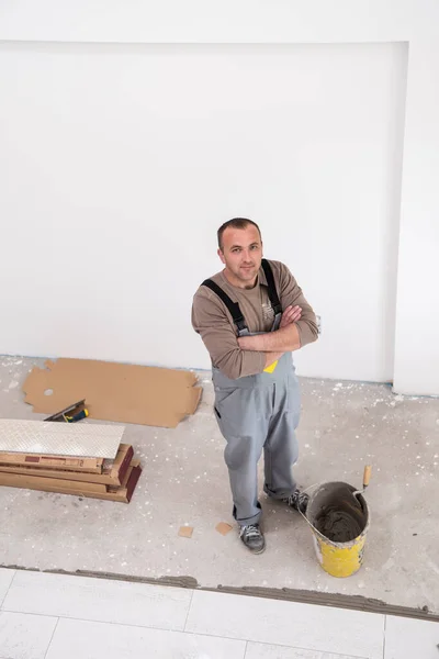床にセラミックウッド効果タイルを設置する熟練労働者新しいアパートの建設現場に積層床を作る労働者 — ストック写真