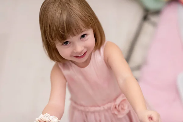 漂亮可爱的小女孩穿着粉红的衣服在家里玩着妈妈的珠宝 — 图库照片