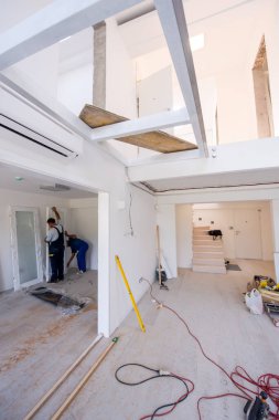 Erkek marangozlar, yeni lüks apartmana iç cam kapı döşüyorlar.