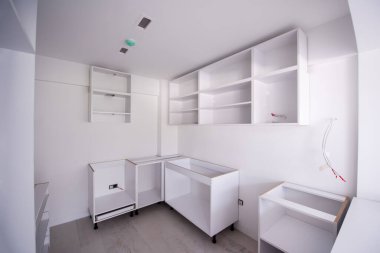 Ahşap dolapları olan lüks bir evde, güzel, parlak, temiz, bitmemiş bir mutfak üzerinde çalışmalar devam ediyor.