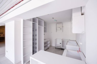 Ahşap dolapları olan lüks bir evde, güzel, parlak, temiz, bitmemiş bir mutfak üzerinde çalışmalar devam ediyor.